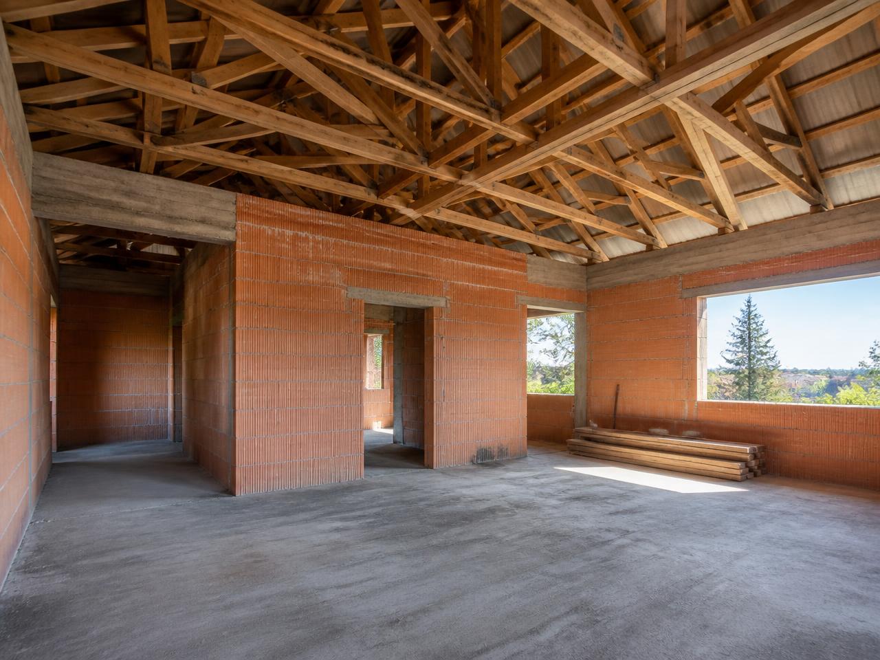 Interieur van een open ruwbouw met snelbouwstenen en dakspanten